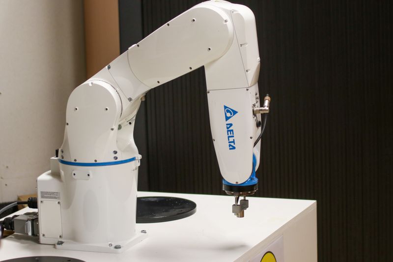 A white robotic arm on a workbench