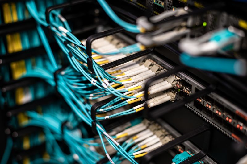 Fiber and ethernet cables plugged into a server rack